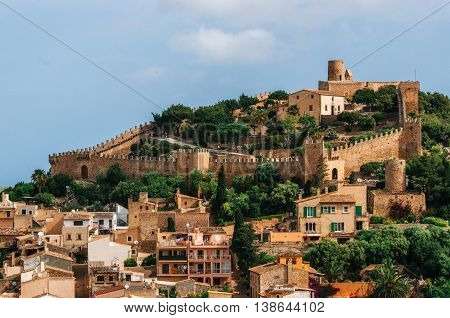 Capdepera castle on green hill in Mallorca island Spain. Beautiful landscape with medieval architecture in Majorca