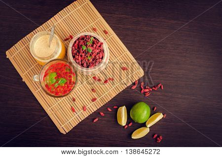 Fresh antioxidant herbal tea from goji berries, lime and honey in  a glass cup. Wolfberry for a healthy diet. Healthy food. Alternative medicine. Recovery. Rejuvenation. Slimming. Top view.