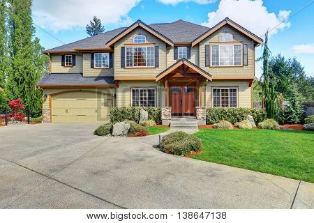 Luxurious Home With Well Kept Lawn And Green Exterior Paint.