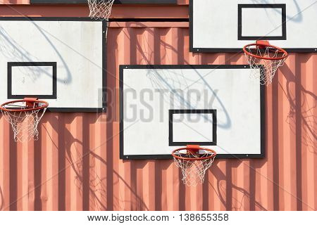 the abstract composition several of basketball baskets with rectangular boards is located on a wall of iron containers