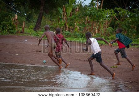 Yongoro Sierra Leone - June 02 2013: West Africa the village of Yongoro in front of Freetown children playing football during a rain storm