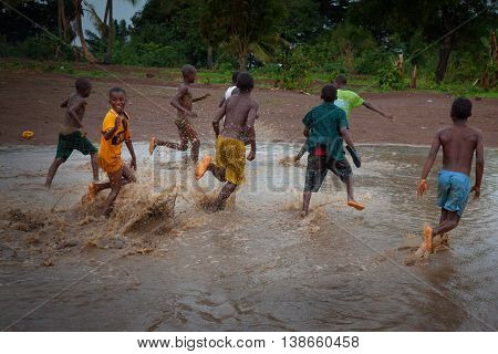 Yongoro Sierra Leone - June 02 2013: West Africa the village of Yongoro in front of Freetown children playing football during a rain storm