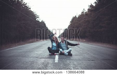 Photo of a boy and girl sits on a road