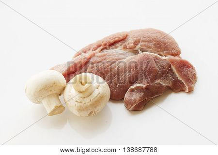 a piece of meat, white background, parsley, tomatoes and mushrooms