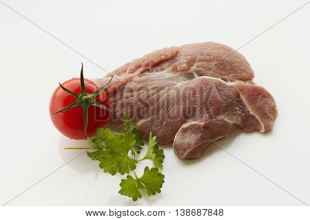 a piece of meat, white background, parsley, tomatoes and mushrooms