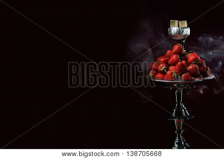 Smoking hookah with fruit head on dark background