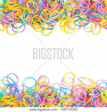 Surface covered with multiple colorful resin loom bands over the white background