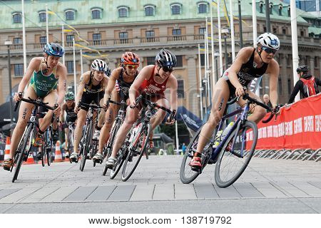 STOCKHOLM - JUL 02 2016: Large group of colorful female triathlete cyclists in a curve from a low angle in the Women's ITU World Triathlon series event July 02 2016 in Stockholm Sweden