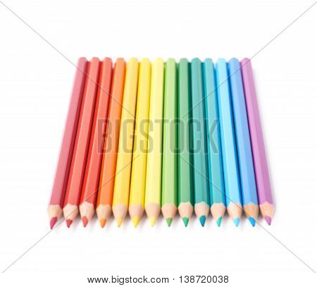 Multiple colorful color pencils composition arranged in a line to form a rainbow gradient, composition isolated over the white background