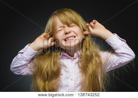 Closeup portrait of worried girl covering her ears, observing. Hear nothing. Human emotions, facial expressions.