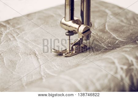 Sewing machine needle wih leather. Part of work process