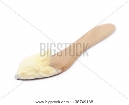 Wooden butterknife with a piece of butter over it, composition isolated over the white background