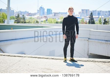 Portrait of a male athlete on the background of the city