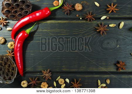 Colorful red hot chili peppers on black wooden table top