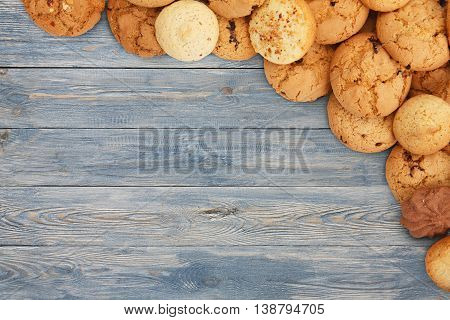 Cookies and sweet biscuits at blue wood, background with copy space. Oatmeal and chocolate drops cookies border, dessert for tea.