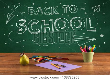 Back to school concepty with writing on blackboard and desk, apple, books, items