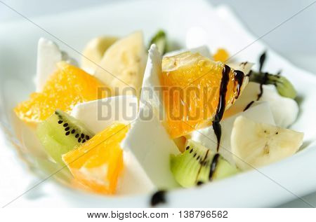 Ice cream with fresh fruit. Sliced bananas oranges kiwi.