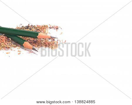 two sharpened green pencils stack on a pile of pencil sawdust isolated on white background