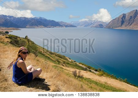 New Zealand woman enjoying the sun and beautiful lakeside view