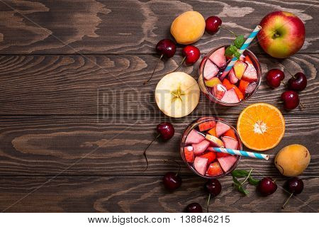 Refreshing sangria or punch with fruits in glasses, top view, copy space