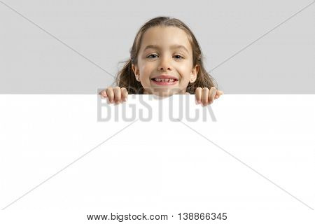 Cute little girl holding a blankboard, with copy space