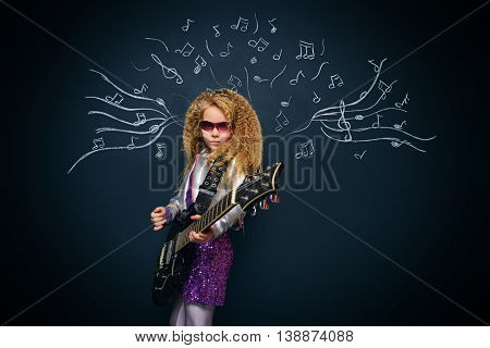 Little rock star singing with her electric guitar over musical background. Music concept.