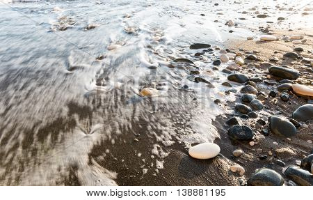 Rocks in soft milky water by the coast in Paphos Cyprus with nice motion blur of the waves