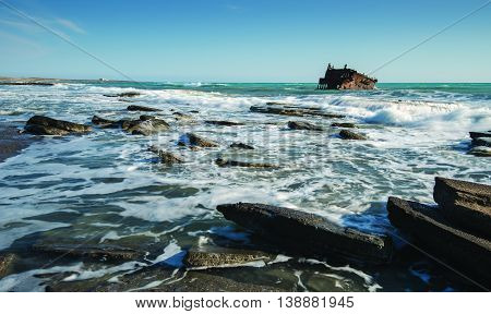 Shipwreck of an abandoned ship on a rocky coast at Akrotiri Beach in Cyprus