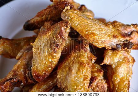 Close-up of spicy chicken buffalo wings. Crispy roasted chicken wings on white plate