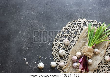 purple spring onions on dark table background