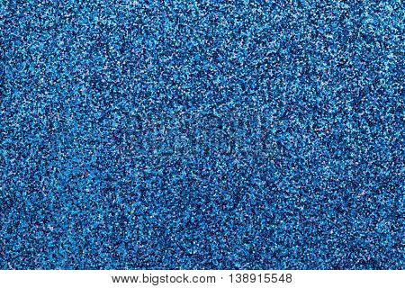 Sparkling background of dark blue small sparkles closeup. Brilliant backdrop.
