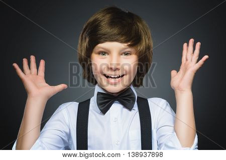 Closeup Portrait of happy boy going surprise isolated on gray background.