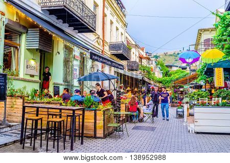 TBILISI GEORGIA - MAY 28 2016: The tourists enjoy the local cuisine on the summer terrace of cafe on May 28 in Tbilisi.