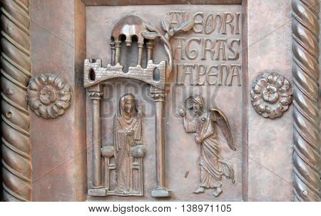 PISA, ITALY - JUNE 06, 2015: Annunciation of the Virgin Mary on the San Ranieri gate of the Cathedral St. Mary of the Assumption in Pisa, Italy on June 06, 2015