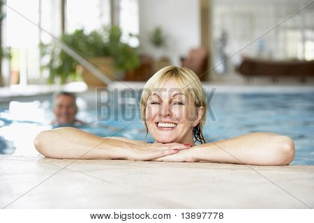 Mitten äldre kvinna bada i Pool