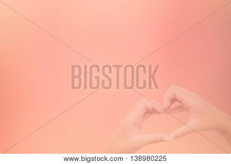 kid hands making a heart shape with sweet background