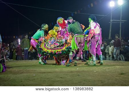BAMNIA PURULIA WEST BENGAL INDIA - DECEMBER 23RD 2015 : Dancer dressed as monsters carrying out their dead leader Chhau Dance festival. It is a very popular Indian tribal martial dance performed at night amongst spectators.