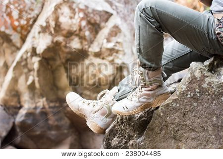 Close Up Foot Of A Hiker Sitting On A Rock In The Midst Of Nature.
