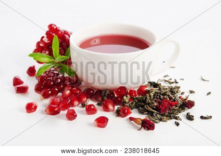 Parts Of A Pomegranate With Pomegranate Seeds And Leaves, Flowers, Dry Tea Of Carcade And Full Cup O