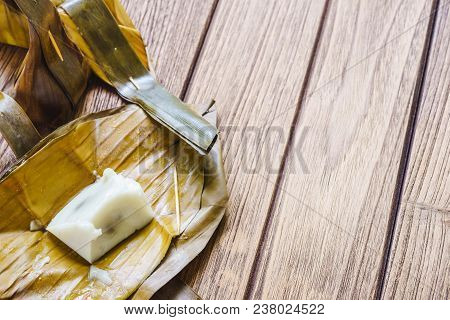 Thai Dessert Steamed Flour With Coconut Filling Or Kanom Sai Sai On Wooden Background With Copy Spac