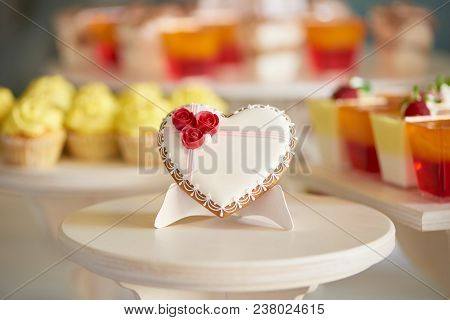 Glazed Gingerbread Heart Stands On The Wooden Stand In The Restaurant. It S Decorated With Sweet Red