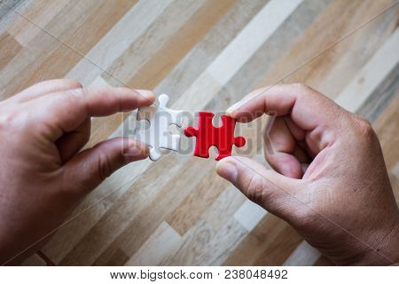 The Hands Of Businessmen Who Are Connecting White And Red Jigsaw, The Concept Of Doing Business Toge