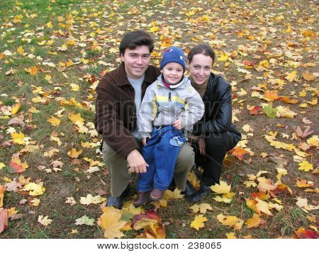 Familia de sonrisa en hojas de otoño