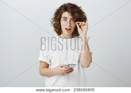 Portrait Of Curious Amazed Beautiful European Woman With Short Curly Hair, Taking Off Glasses And Dr