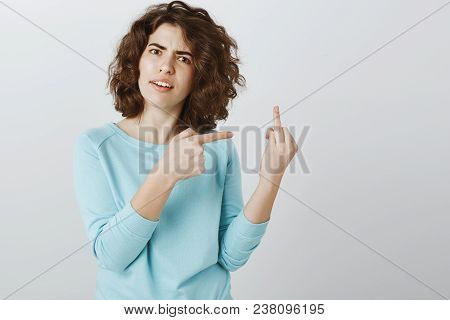 Maybe You Should Go Fuck Yourself. Portrait Of Angry Offended Young Woman With Curly Hair, Showing D