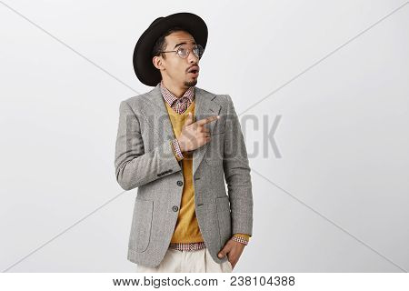 What Is This Shocking Thing. Studio Shot Of Wondered Dark-skinned Employer In Stylish Hat And Flasse
