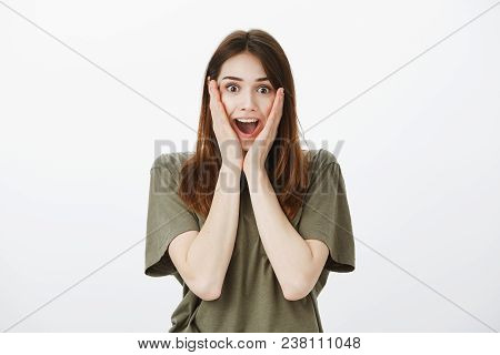Excited Cute Girlfriend Screaming From Positive Surprise, Amazed. Studio Shot Of Overwhelmed Wondere