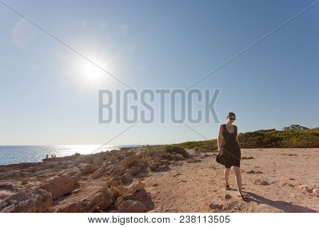 Cap De Ses Salines, Mallorca, Spain - A Young Woman Going Out For A Walk At The Beach Of Ses Salines