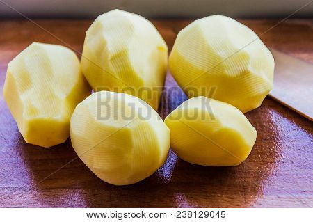 Peeled Potatoes On A Wooden Board, Slicing And Cooking Fried Potatoes