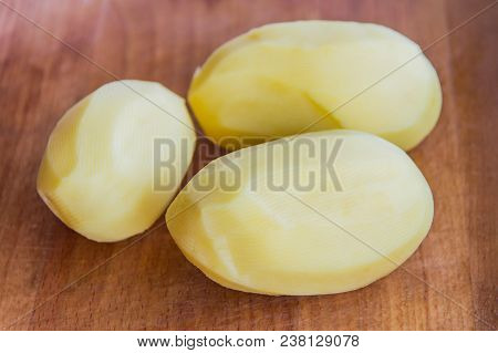 Peeled Potatoes On A Wooden Board, Slicing And Cooking Fried Potatoes